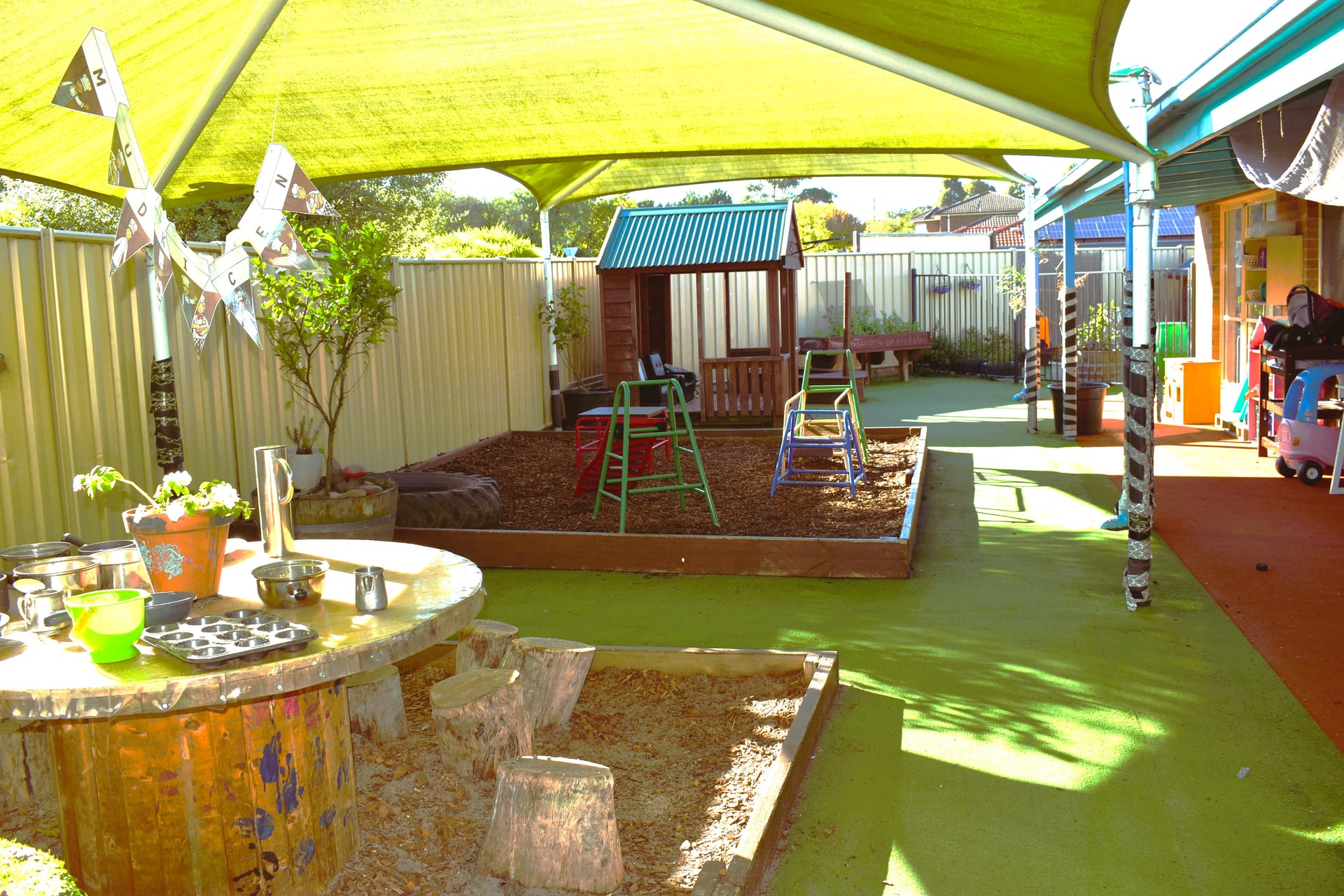 Outdoor play area — shade sail, mud kitchen and climbing equipment